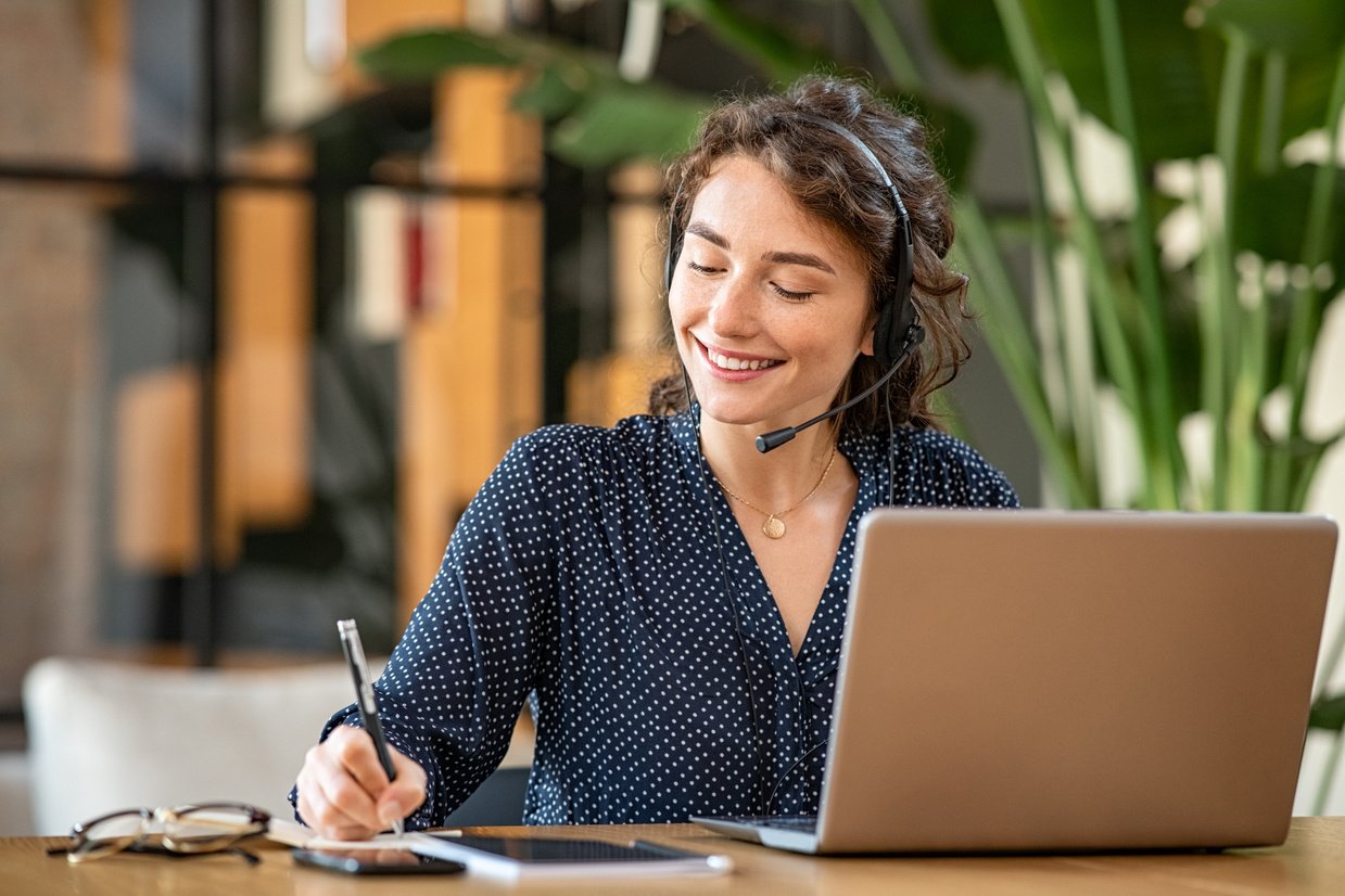 Friendly customer service representative at a desk ready to assist, providing contact information for Help Me Plan Travel.